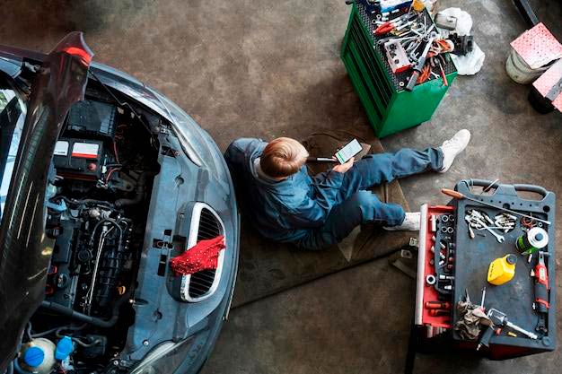 Free photo top view man repairing car